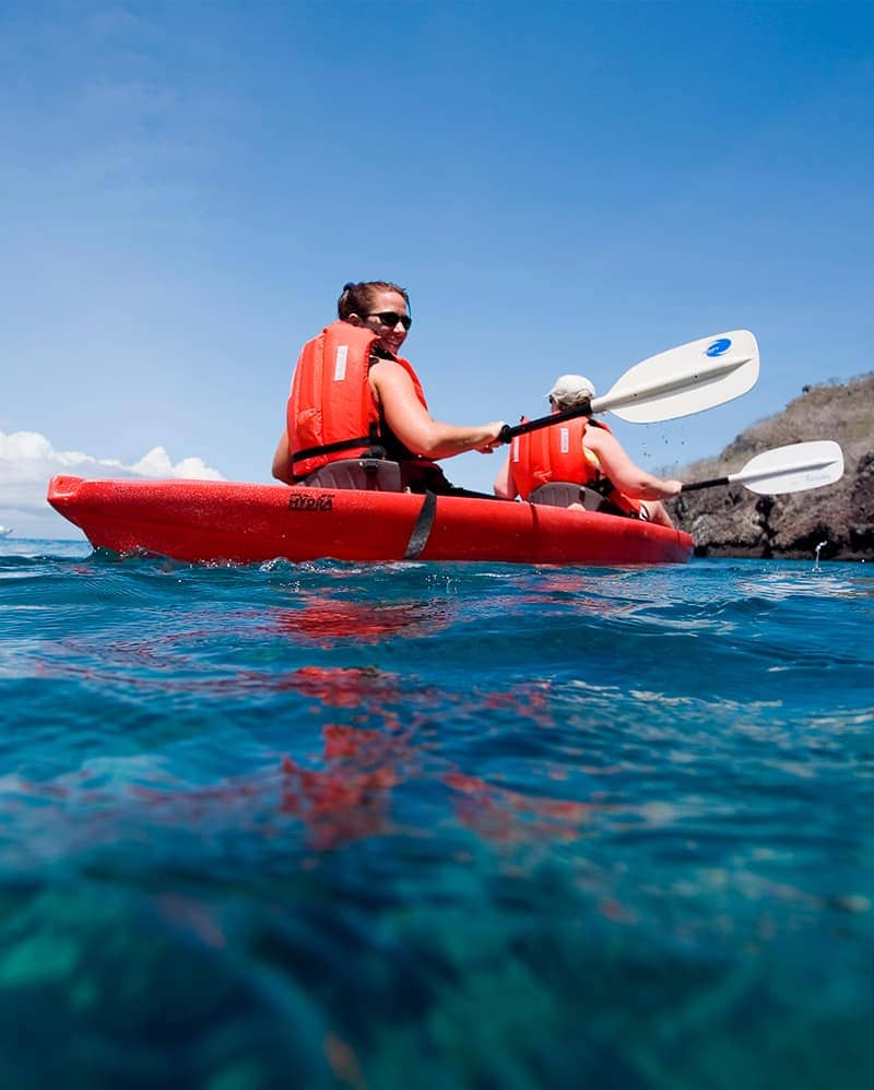 Woman kayaking in the ocean with a life vest in the Galapagos Islands